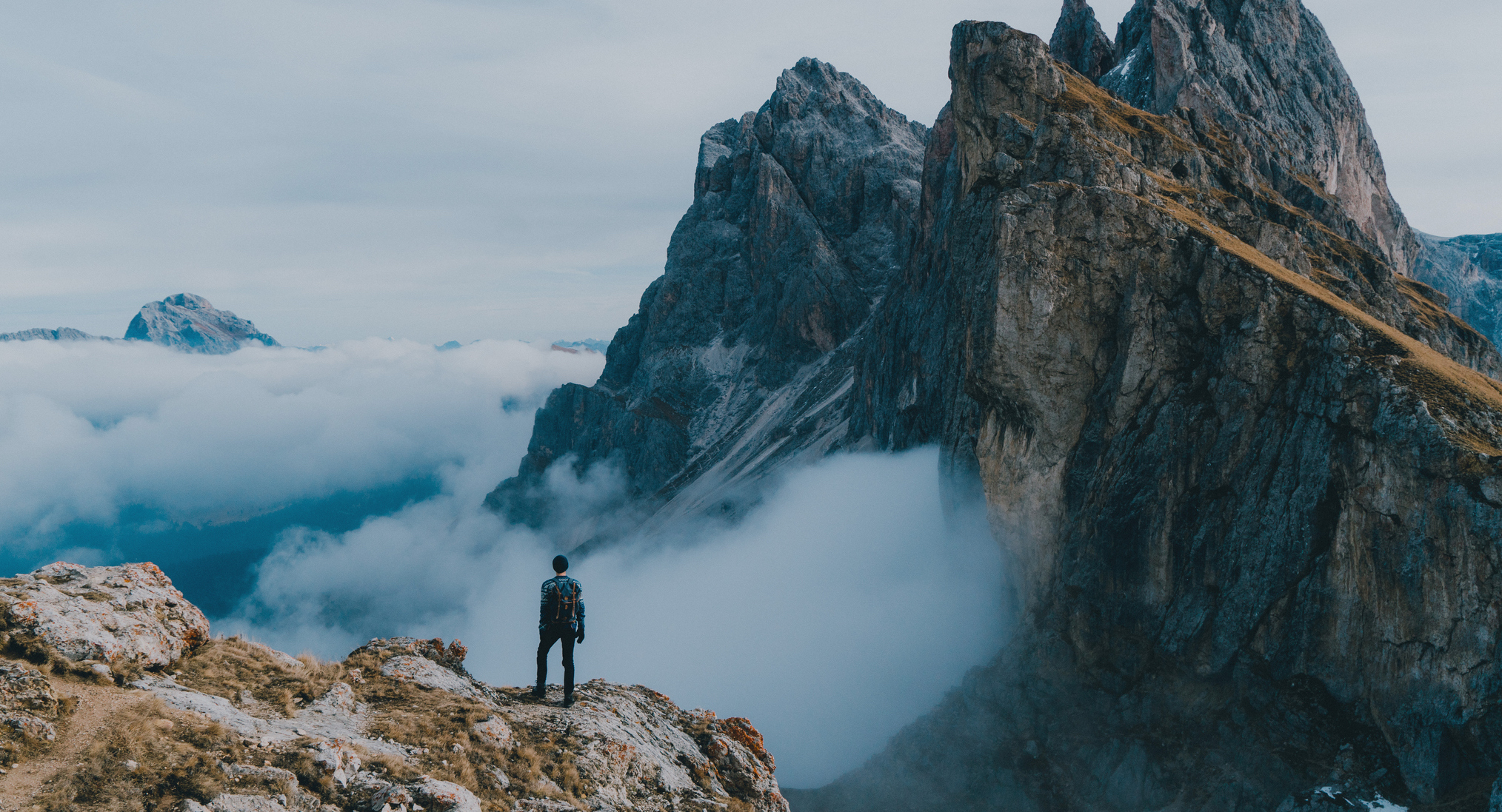 Young Caucasian man  hiking near Seceda mountain in Dolomites